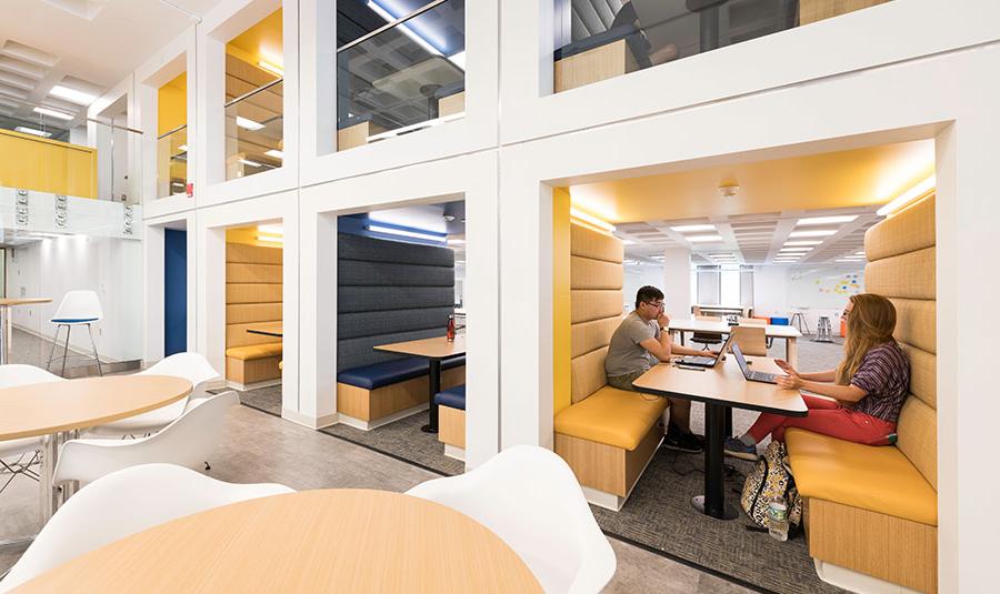 Two students studying at a table in a library at 的 University of Rochester