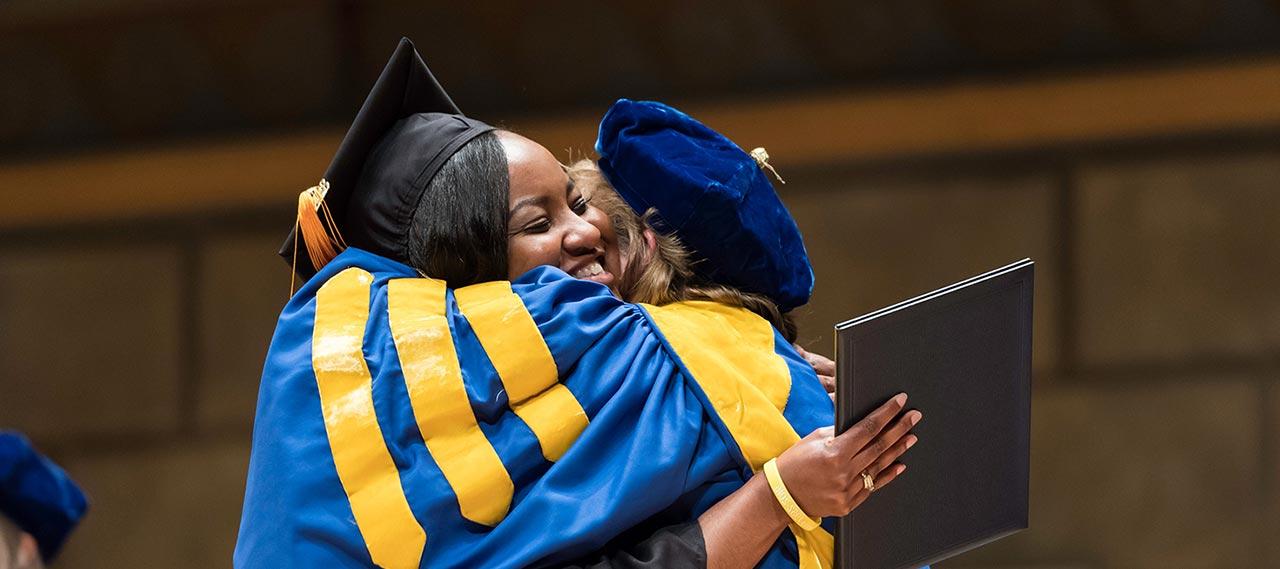 A woman receiving her degree at commencement.