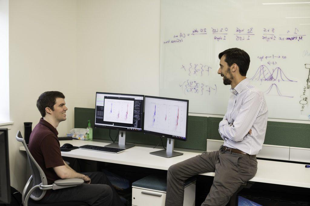 Student and professor looking at data set in a computer 实验室